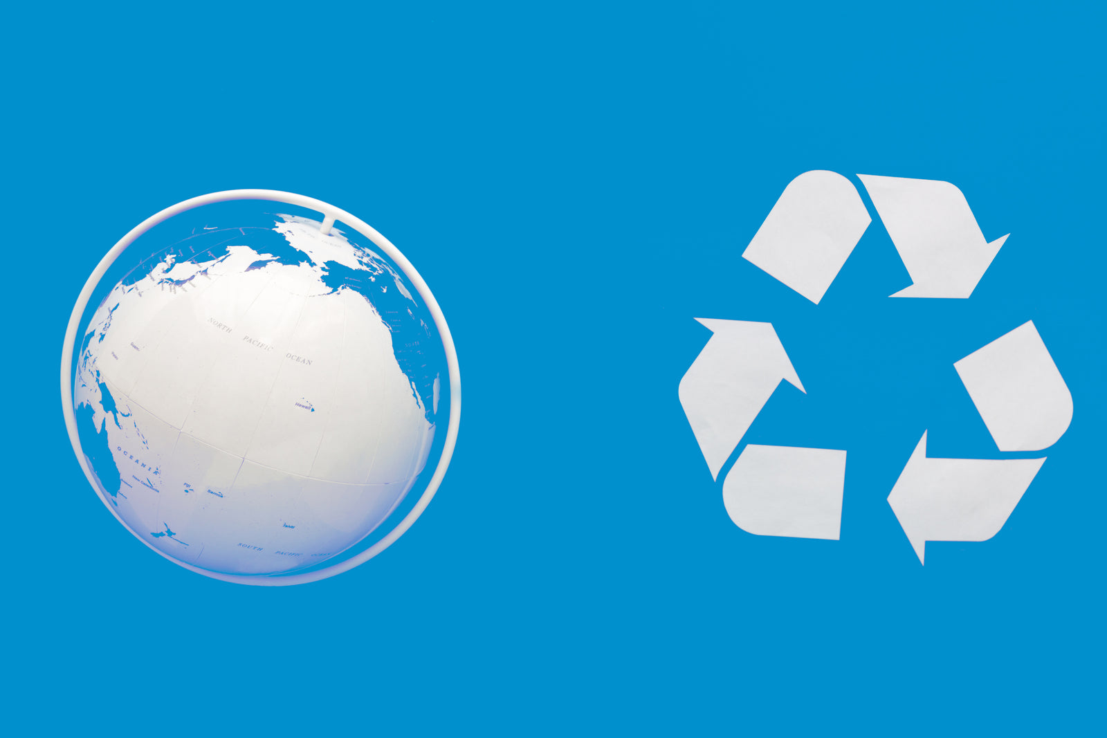 Recycling symbol on a green field